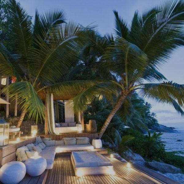 Beach-front property with palm trees and chairs